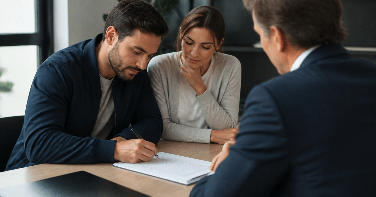 Deux personnes signant document hypothecaire devant agent immobilier