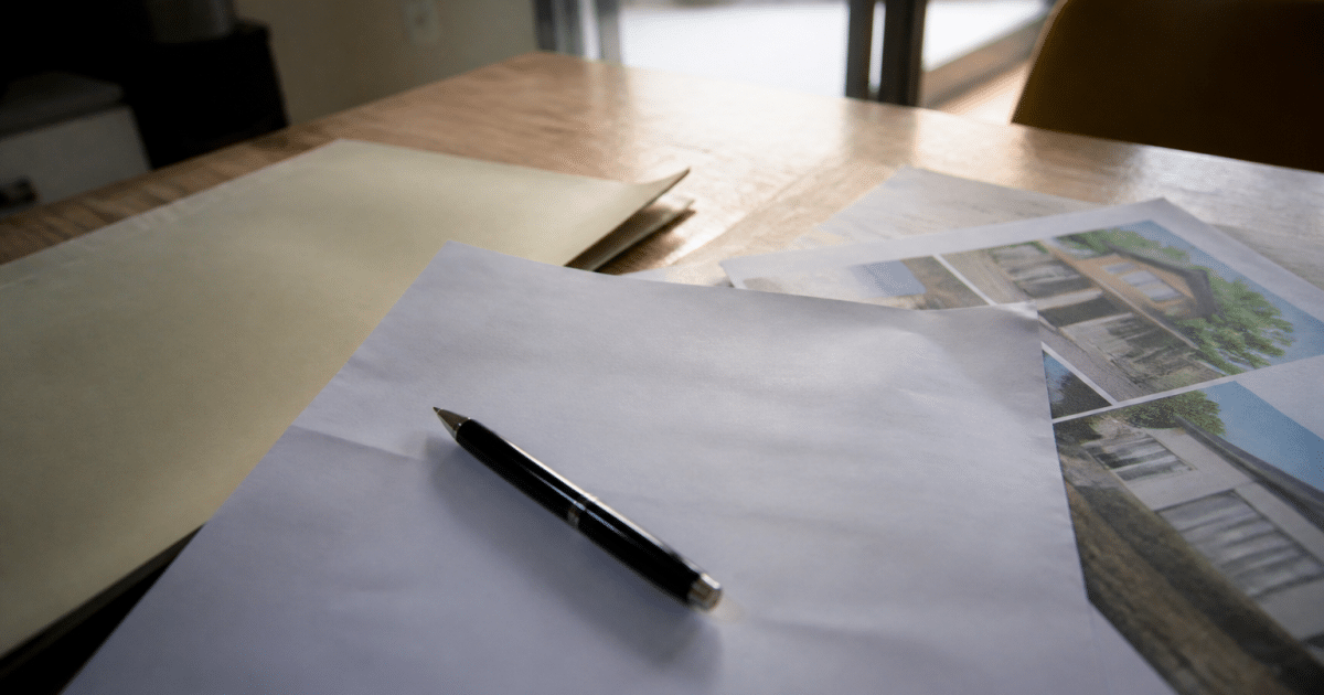 Certificat bancaire posé sur table avec stylo et documents immobiliers