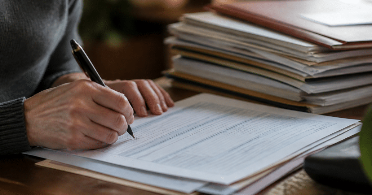 Formulaire fiscal rempli avec stylo et documents immobiliers empilés