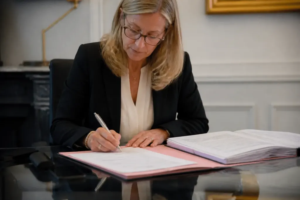 Notaire signant acte vente avec documents impots
