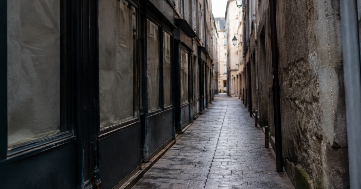 Allee sombre avec vitrines obturees et murs sales