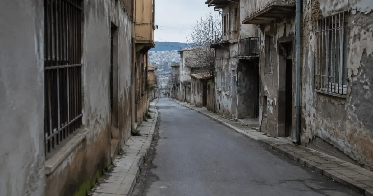 Rue déserte de quartier urbain avec immeubles délabrés et murs gris