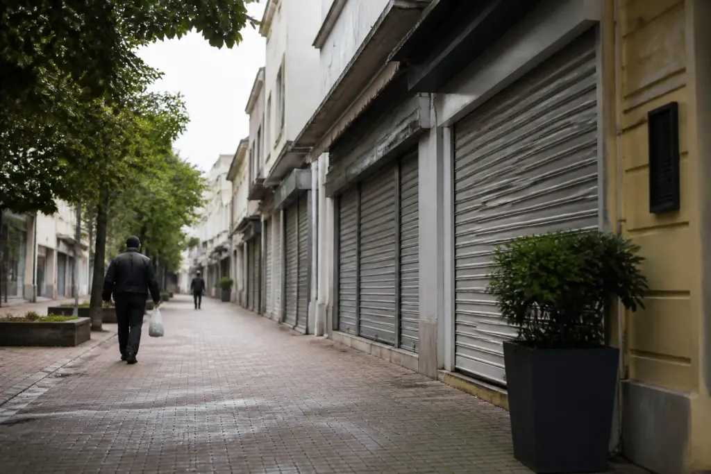 Rue calme avec commerces fermés et few residents walking