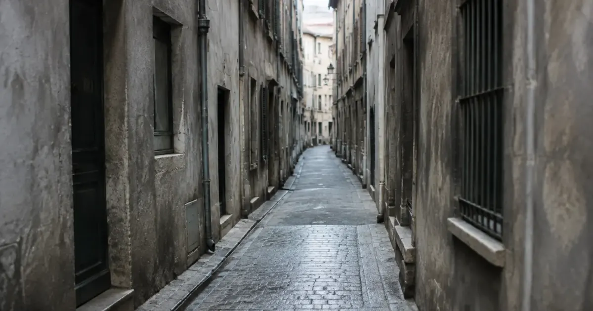 Rue etroite entre immeubles gris aux facades degradees