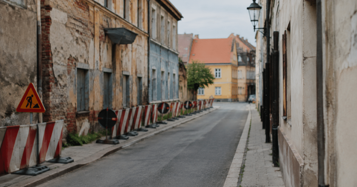 Rue urbaine delimitee avec panneaux d'avertissement et batiments degrades