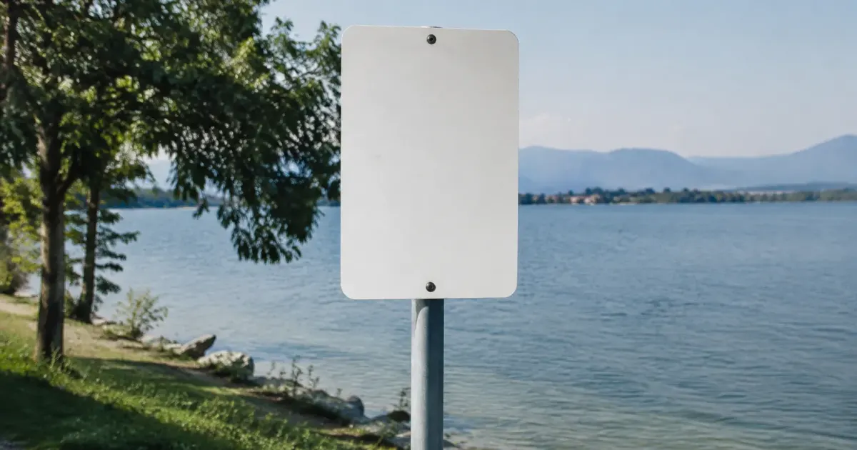 Panneau blanc de ville planté au bord du lac