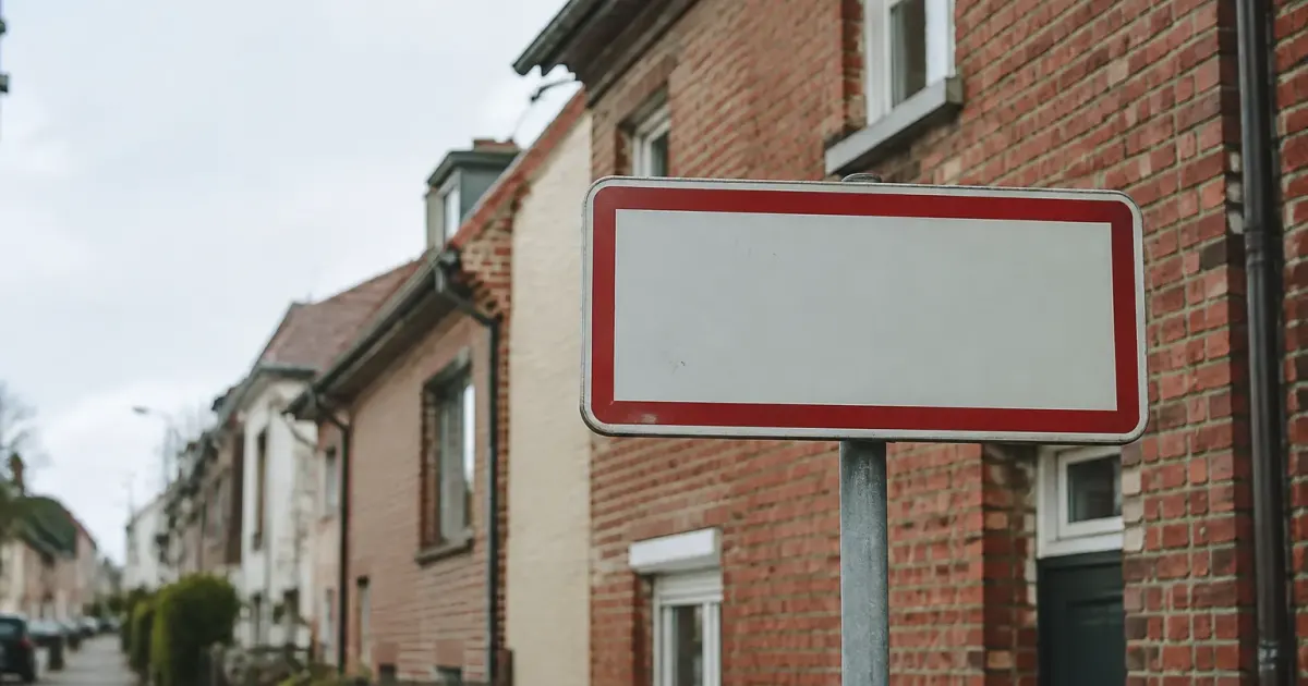 Panneau de ville devant des maisons en briques
